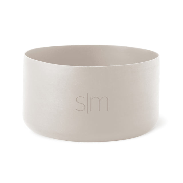 Pale cream-colored cylindrical vessel with soft gray interior walls against a neutral background. Pale cream-colored cylindrical vessel with soft gray interior walls against a neutral background.