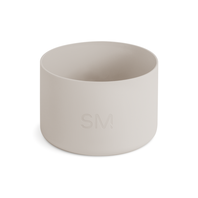 Off-white matte cylindrical boot product on pale beige background. Neutral, warm cream color palette with soft lighting. Off-white matte cylindrical boot product on pale beige background. Neutral, warm cream color palette with soft lighting.