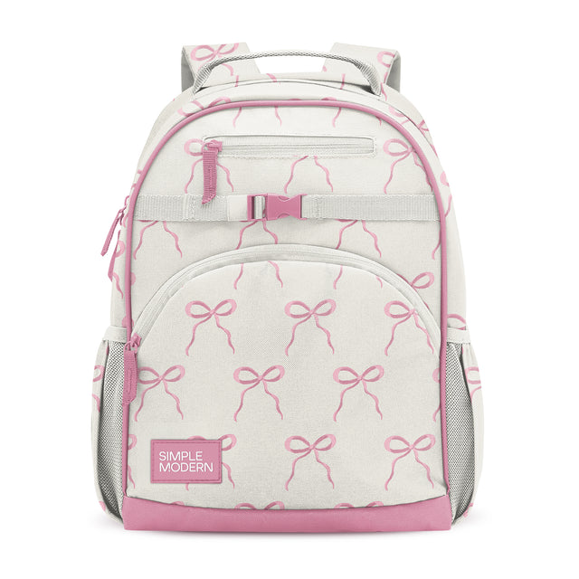 Cream and pink children's backpack with bow pattern, zippered pockets, mesh side compartments, padded straps, and Simple Modern branding label on front pocket. Cream and pink children's backpack with bow pattern, zippered pockets, mesh side compartments, padded straps, and Simple Modern branding label on front pocket.