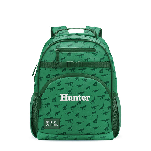 Kelly green children's backpack with dinosaur pattern, padded straps, front zippered pocket labeled Kelly green children's backpack with dinosaur pattern, padded straps, front zippered pocket labeled