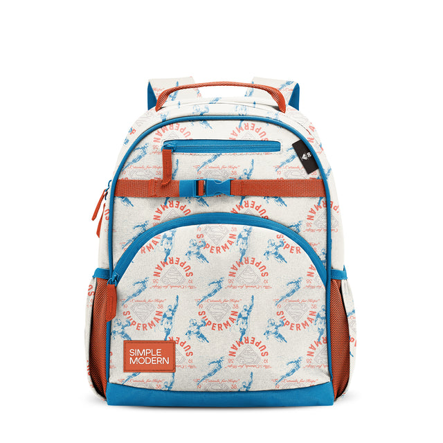 Cream and blue Superman backpack with orange handles and chest strap, featuring scattered Superman text and illustrations, dual padded shoulder straps, front zippered pocket, and Simple Modern brand label on white background. Cream and blue Superman backpack with orange handles and chest strap, featuring scattered Superman text and illustrations, dual padded shoulder straps, front zippered pocket, and Simple Modern brand label on white background.