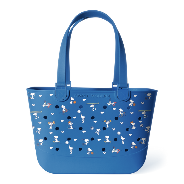 Blue Peanuts tote bag with dual handles, perforated front panel, and character print featuring Snoopy playing sports and activities in white and orange. Simple Modern branding on solid blue base. Blue Peanuts tote bag with dual handles, perforated front panel, and character print featuring Snoopy playing sports and activities in white and orange. Simple Modern branding on solid blue base.