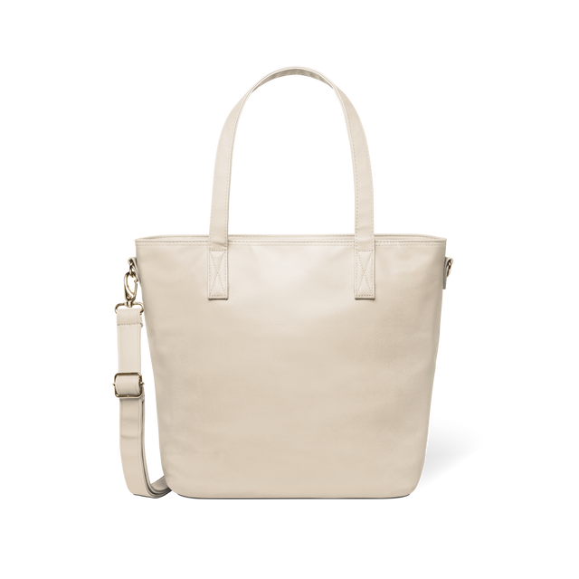 Oatmeal-colored tote bag with gold-toned metal hardware and handles against a white background Oatmeal-colored tote bag with gold-toned metal hardware and handles against a white background