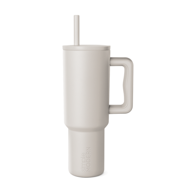 Beige signature tumbler with handle and straw on neutral background Beige signature tumbler with handle and straw on neutral background