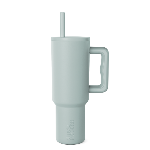 Sage green signature tumbler with handle and reusable straw, displayed on white background. Modern drinkware design with soft muted color and cylindrical shape. Sage green signature tumbler with handle and reusable straw, displayed on white background. Modern drinkware design with soft muted color and cylindrical shape.