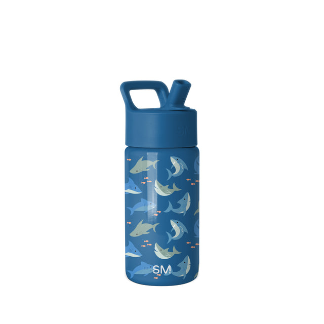 Navy blue insulated water bottle with integrated carry handle and flip-top spout, featuring playful illustrated sharks, whales, and fish in cream and orange accents. Simple Modern brand logo visible. Navy blue insulated water bottle with integrated carry handle and flip-top spout, featuring playful illustrated sharks, whales, and fish in cream and orange accents. Simple Modern brand logo visible.