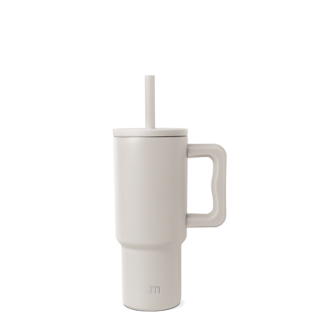 Cream-colored tumbler with handle and reusable straw, modern design with warm beige undertones Cream-colored tumbler with handle and reusable straw, modern design with warm beige undertones