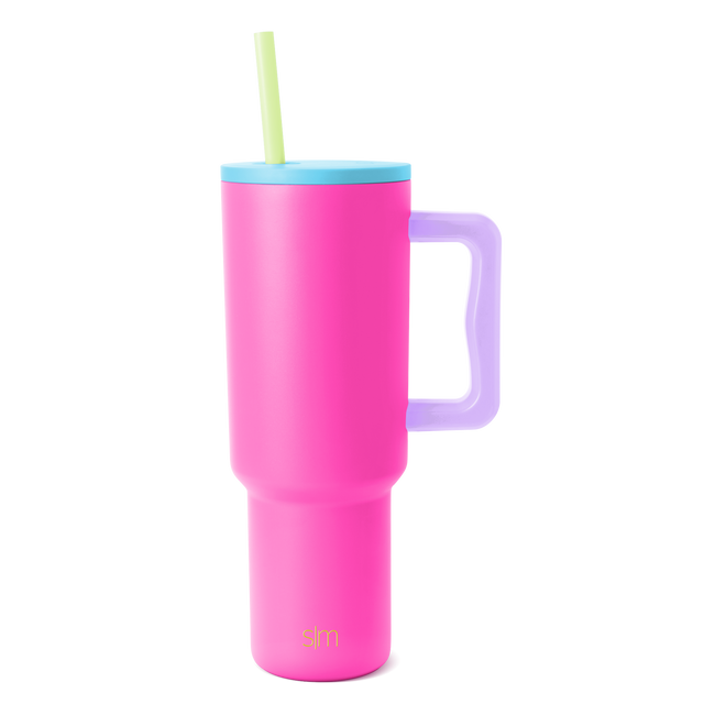 Trek Tumbler insulated beverage cup with hot pink body, sky blue lid, lavender purple handle, and pale yellow-green straw on white background Trek Tumbler insulated beverage cup with hot pink body, sky blue lid, lavender purple handle, and pale yellow-green straw on white background