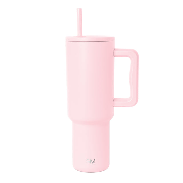 Soft pink insulated tumbler with handle and matching straw on white background. Simple Modern logo visible on lower front. Modern minimalist design with cylindrical shape and fitted lid. Soft pink insulated tumbler with handle and matching straw on white background. Simple Modern logo visible on lower front. Modern minimalist design with cylindrical shape and fitted lid.