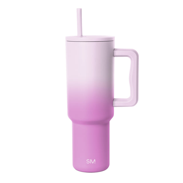 Simple Modern insulated tumbler with lavender-to-magenta ombre gradient, featuring a handle, matching lid with straw, and SM logo on white background. Simple Modern insulated tumbler with lavender-to-magenta ombre gradient, featuring a handle, matching lid with straw, and SM logo on white background.