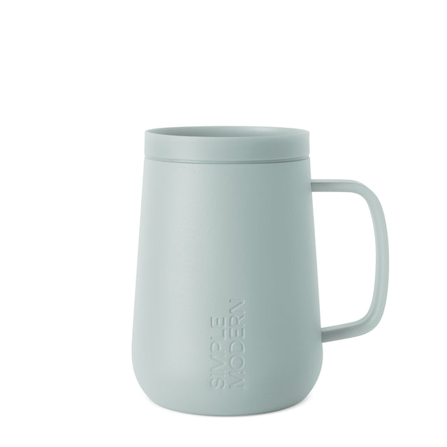 Soft sage green ceramic mug with handle on light gray background Soft sage green ceramic mug with handle on light gray background