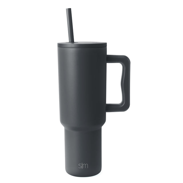 Charcoal gray Trek Tumbler with tapered cylindrical design, fitted lid, centered straw, and rectangular handle against white background