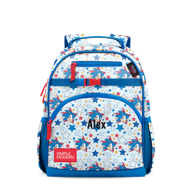 White and blue children's backpack with Sonic character graphics and stars. Features dual padded shoulder straps, multiple zippered compartments, red mesh side pockets, and 