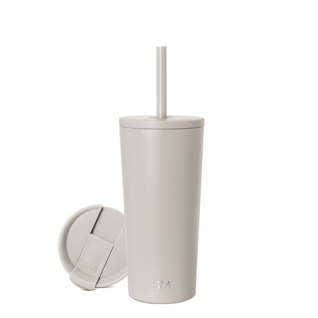 Beige cylindrical tumbler with matching lid on neutral background