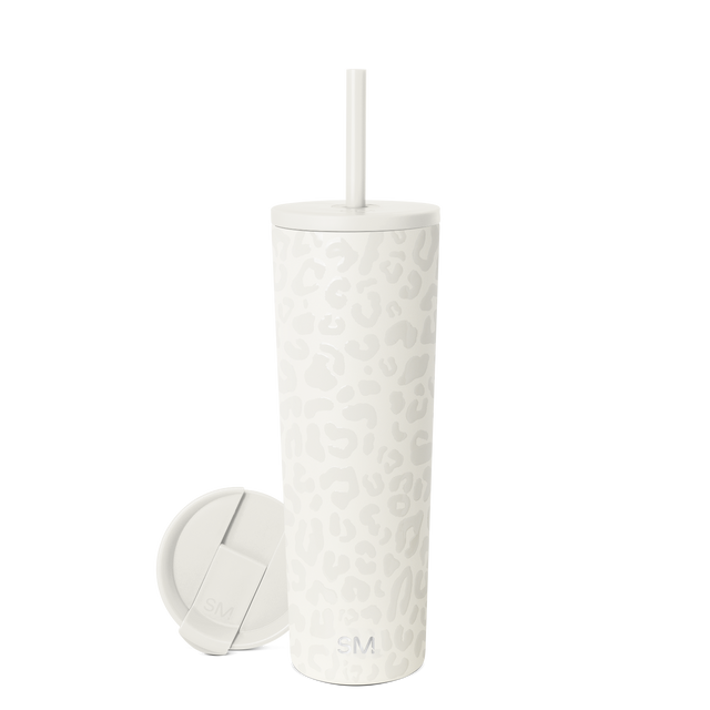 Cream-colored cylindrical tumbler with textured pattern and metal accents on soft neutral background.