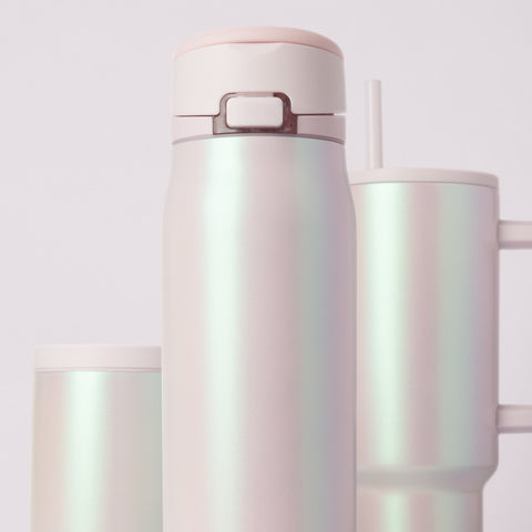 Creamy off-white pearlescent drinkware with iridescent highlights shifting between pale pink and soft green tones