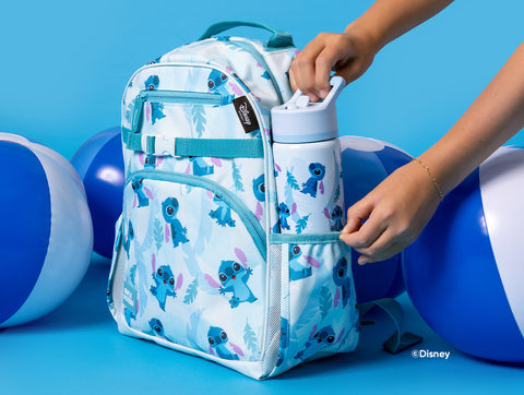 Disney Stitch children's backpack and water bottle set with turquoise and white colors, tropical leaf patterns, and repeating character illustrations, displayed against a bright blue background with decorative balloons.