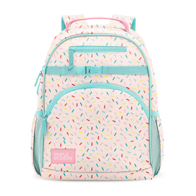 Pastel pink children's backpack with turquoise trim, colorful confetti dashes, three zippered compartments, side mesh pockets, turquoise handles, and Simple Modern label, photographed front-facing on white background.