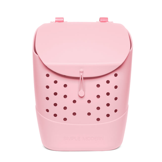 Pale pink structured backpack with burgundy perforations, rounded silhouette, curved flap closure, rectangular handles, central drawstring, and trapezoidal base against white background. Text reads 