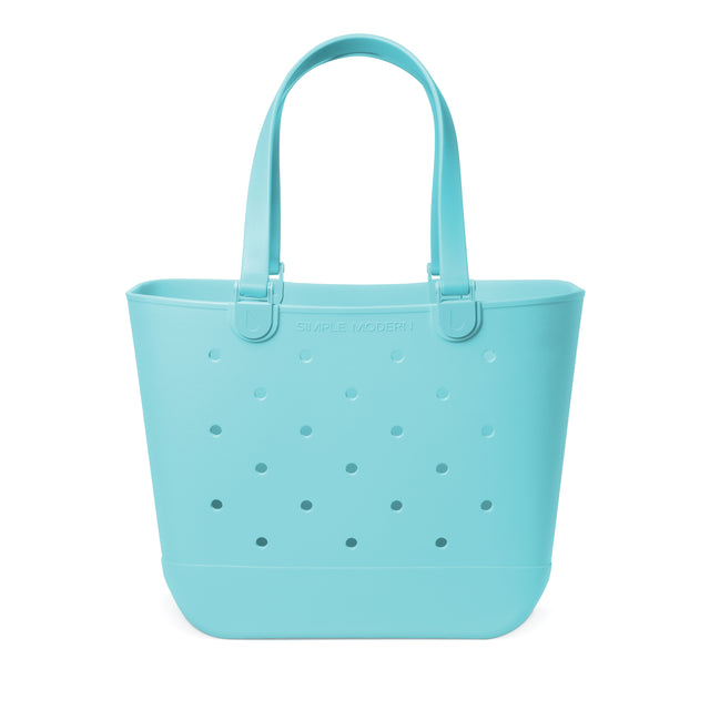 Soft turquoise perforated tote bag with padded handles and flat bottom against white background. Features 