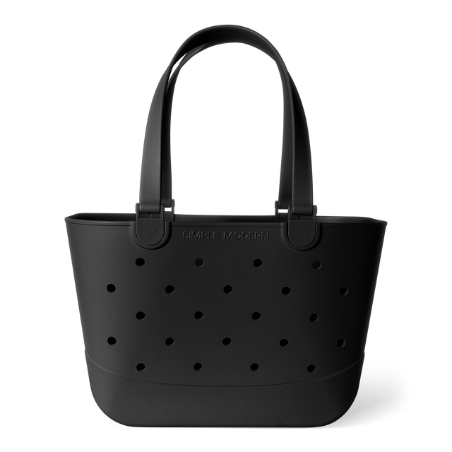Matte black tote bag with perforated grid pattern and curved handles on white background. Features 