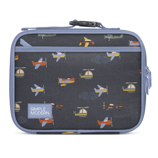 Charcoal gray lunch box with periwinkle blue trim and handles, featuring interior pattern of colorful aircraft in orange, yellow, blue, and cream.