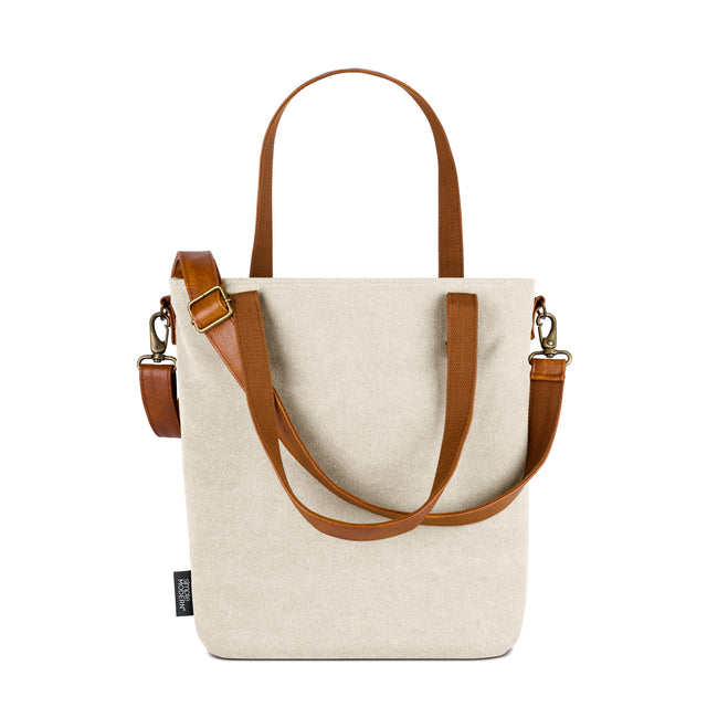 Cream canvas tote bag with cognac brown and tan leather accents and handles