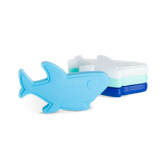 Four stackable shark-shaped ice cube trays in sky blue, mint green, white, and navy blue arranged against a white background.