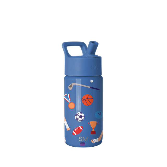 Cobalt blue Simple Modern kids water bottle with push-button flip-top lid and carry handle, featuring sports-themed graphics including basketball, soccer ball, football, and trophy in orange, red, and white.