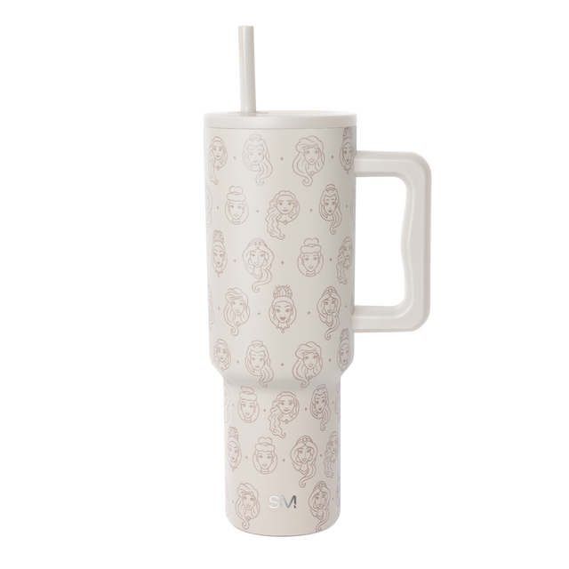 Cream-colored insulated tumbler with rose gold line-drawn female portrait pattern, white handle and straw, Simple Modern logo, against white background.