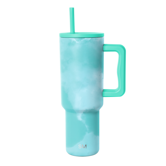 Turquoise tie-dye tumbler with matching handle and lid, featuring a cloudy blue-green ombre pattern throughout the body
