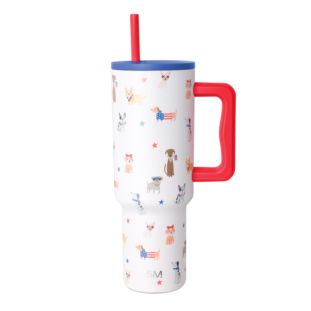 White insulated tumbler with handle featuring patriotic dog-themed pattern with various dog breeds wearing patriotic accessories on white background